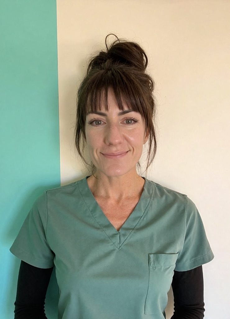 Woman in scrubs against a colorful background.