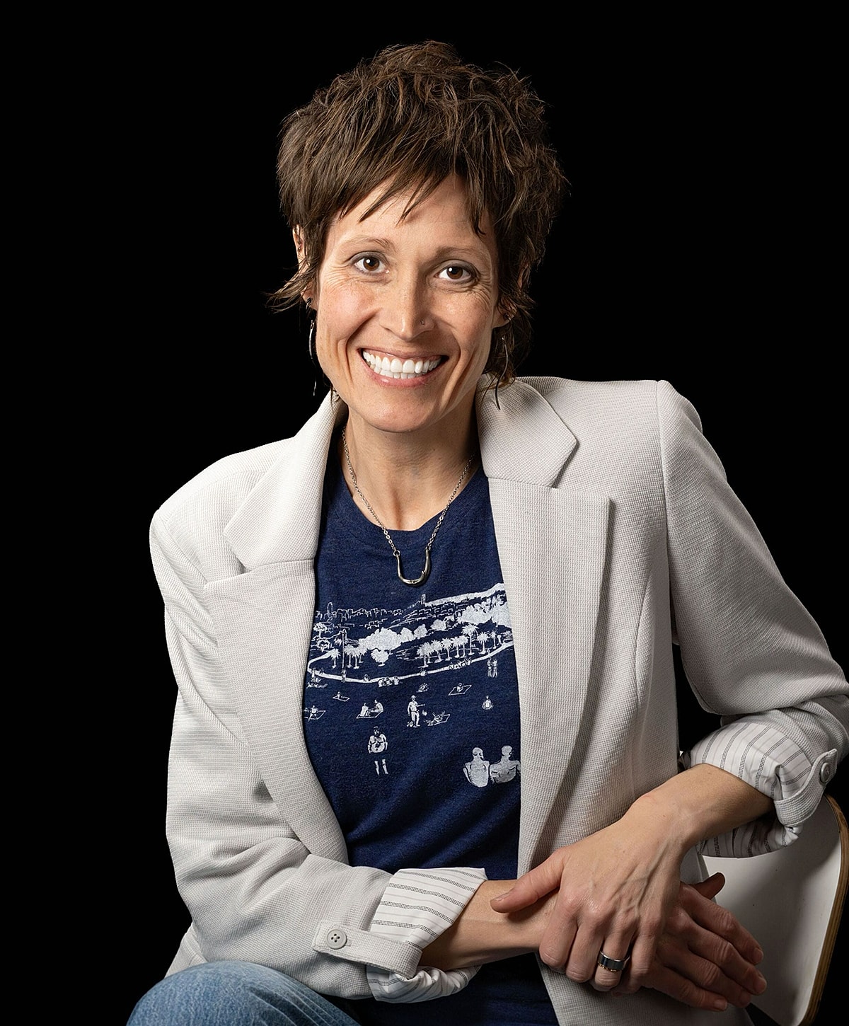 Smiling woman in a blazer against black background