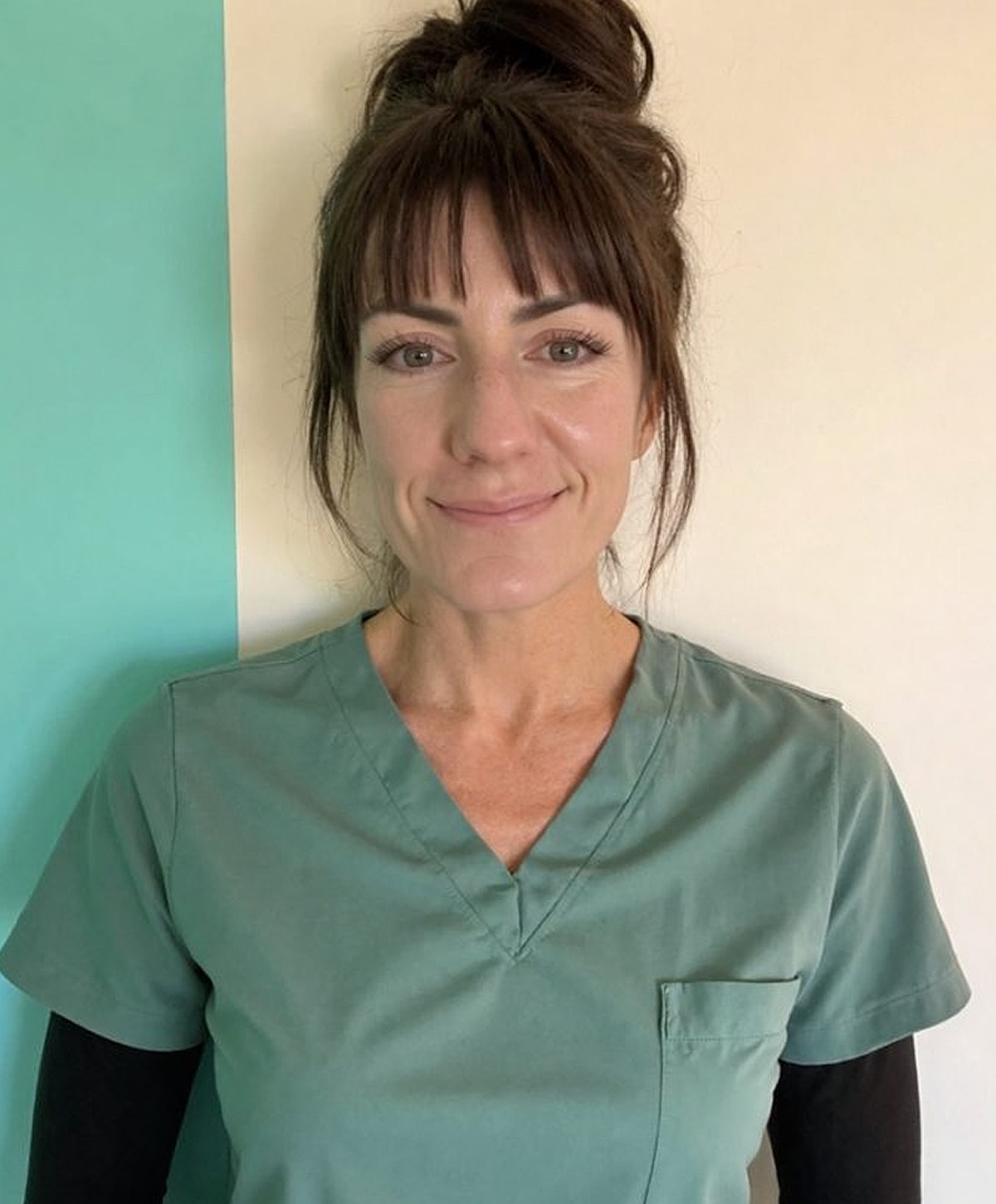 Woman in scrubs against colorful background