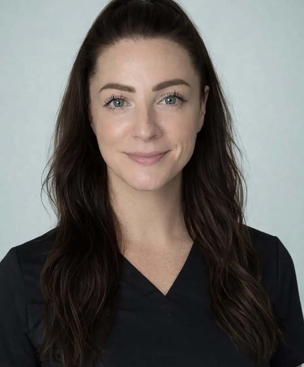 Smiling woman in black top with long hair