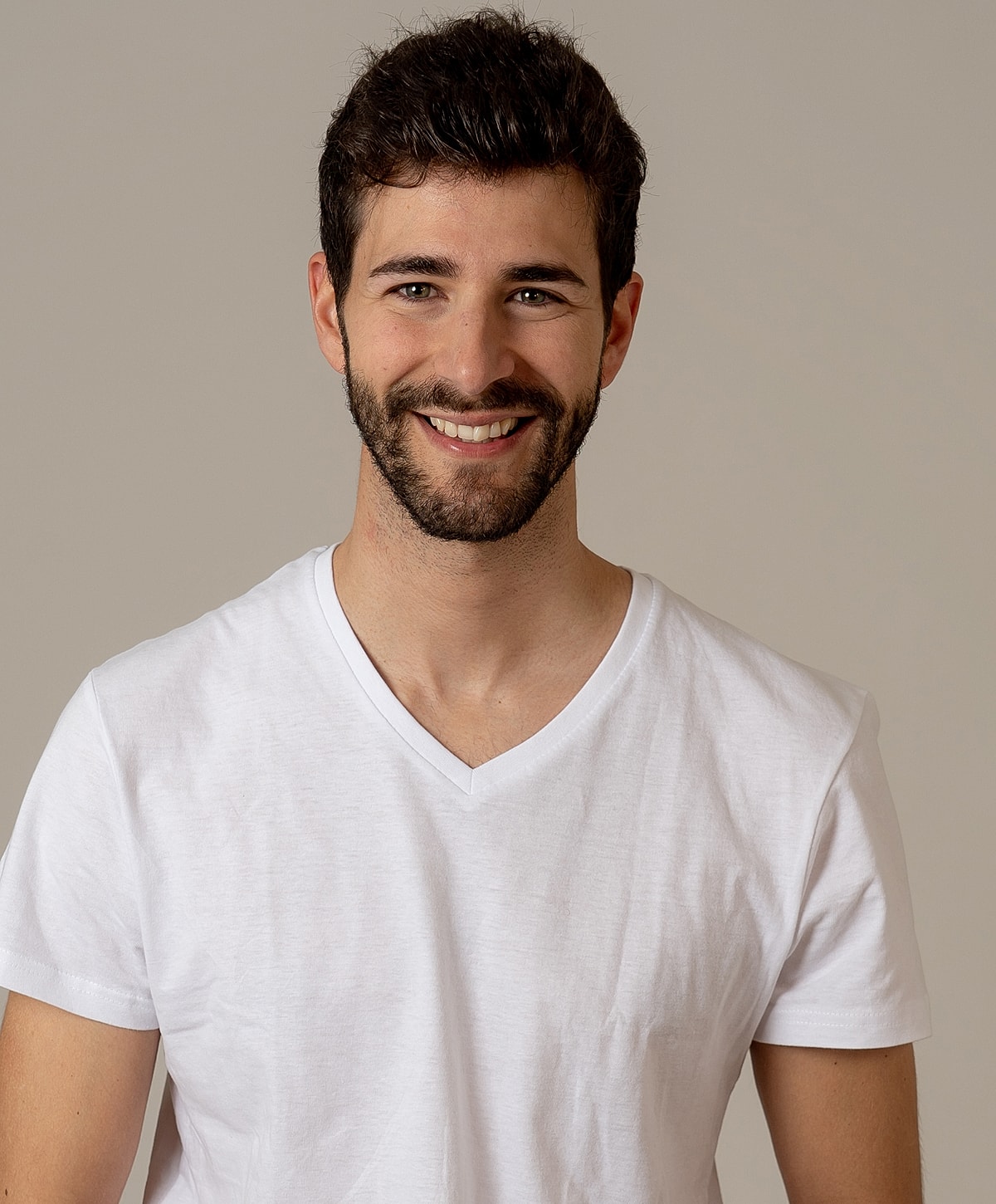 Smiling man in a white v-neck t-shirt.