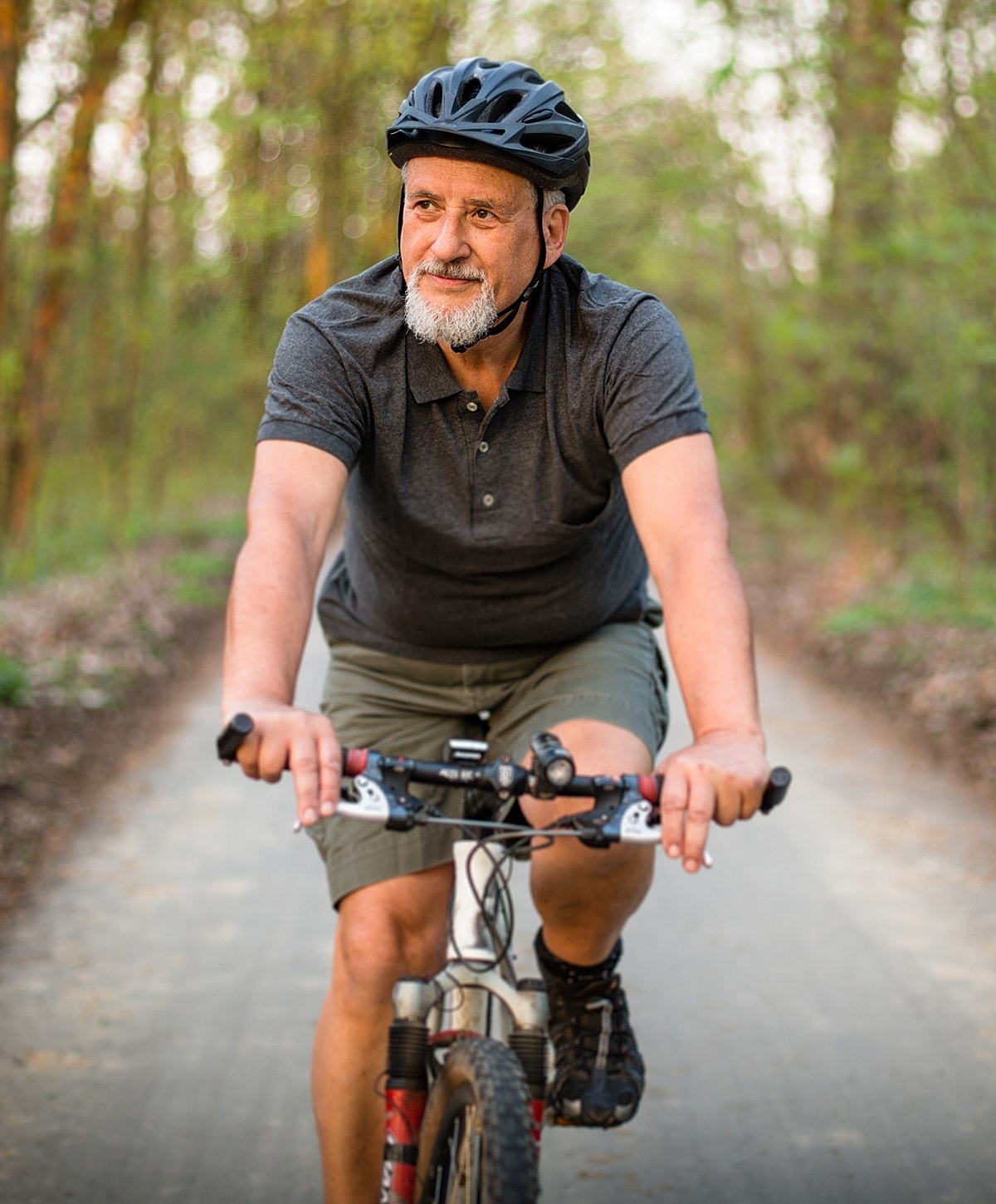 Man cycling on a path through the woods.