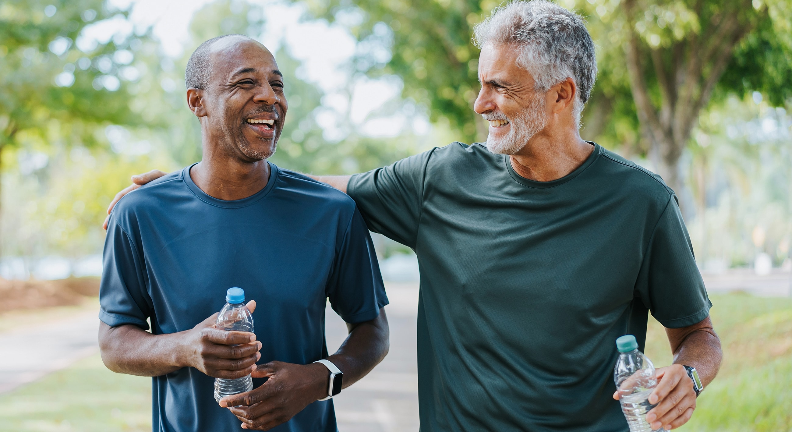 Men enjoying a walk while holding water bottles.