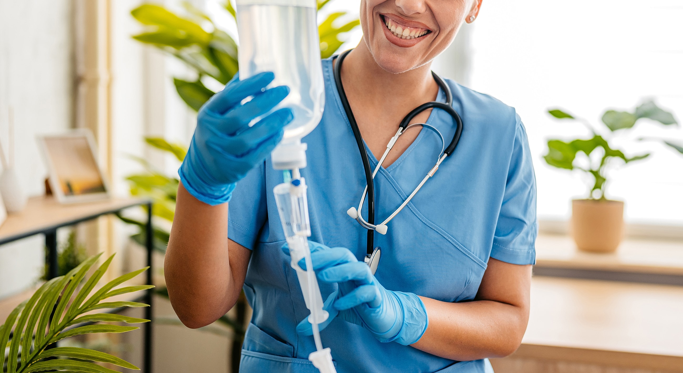 Smiling healthcare professional with IV bag.